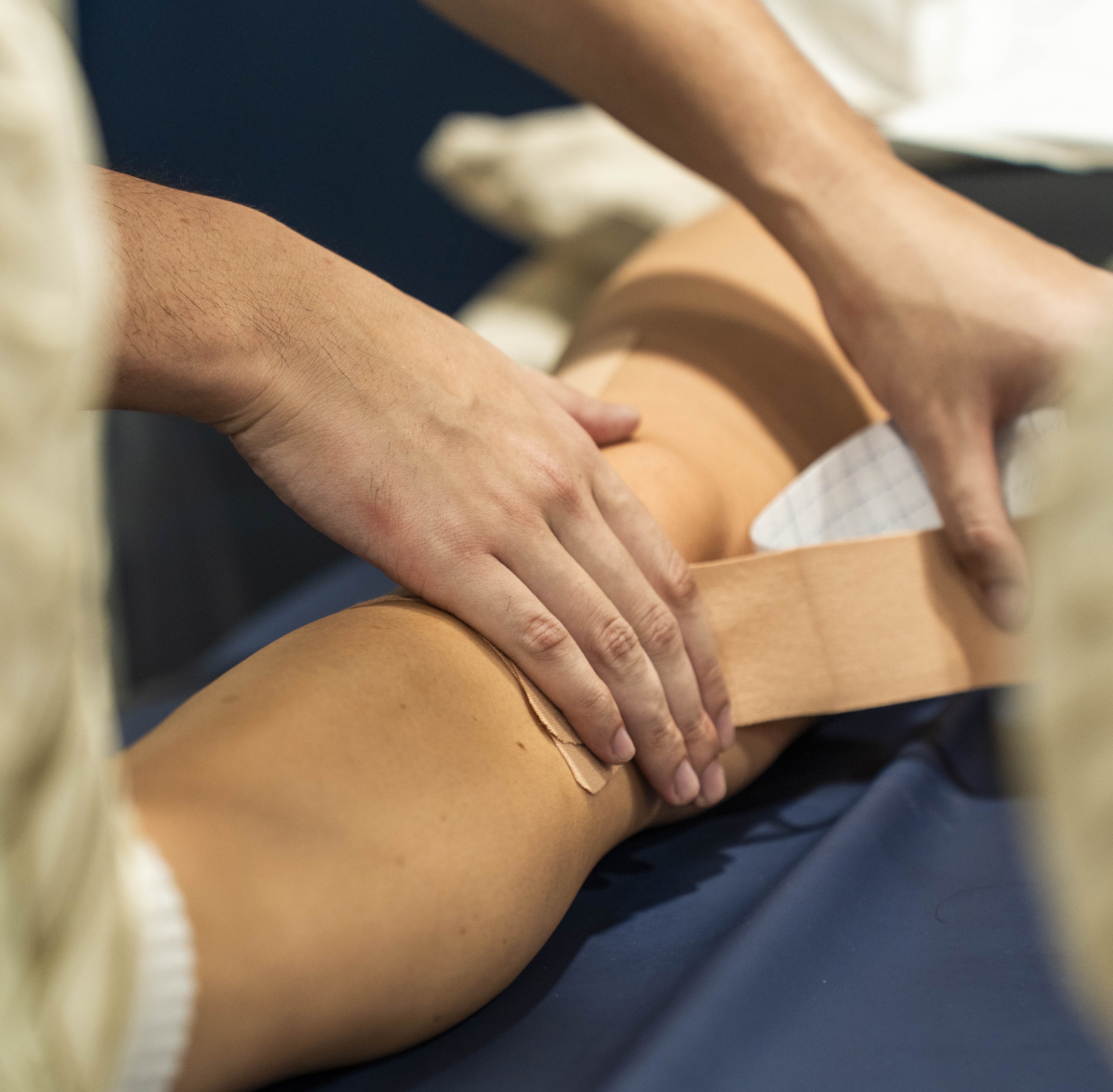 Physiotherapist applying therapeutic sports tape services to a patient’s knee at Wellers Hill Physio